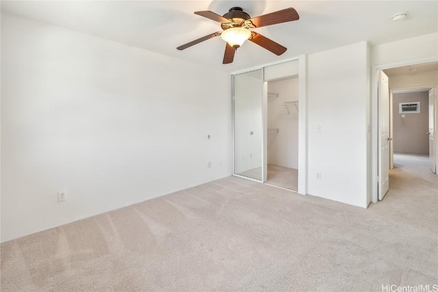 unfurnished bedroom with light carpet, ceiling fan, and a closet