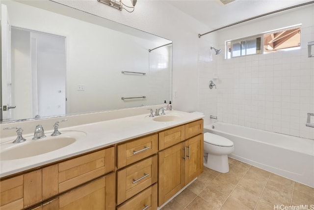 bathroom featuring double vanity, toilet, a sink, and shower / bathing tub combination