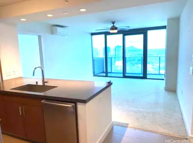 kitchen featuring light carpet, sink, a wall mounted air conditioner, ceiling fan, and stainless steel dishwasher