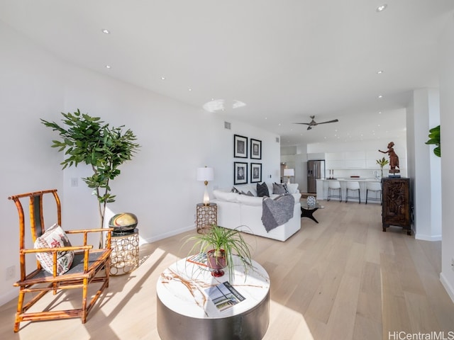 living room with light wood-type flooring and ceiling fan