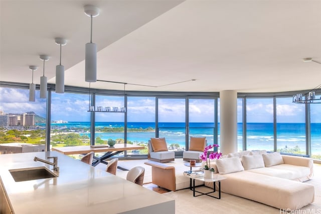 living room featuring expansive windows, a water view, and sink