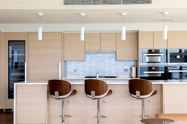 kitchen featuring pendant lighting, hardwood / wood-style flooring, a kitchen breakfast bar, and stainless steel appliances