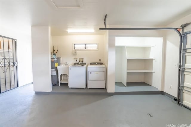 garage with independent washer and dryer, sink, and water heater