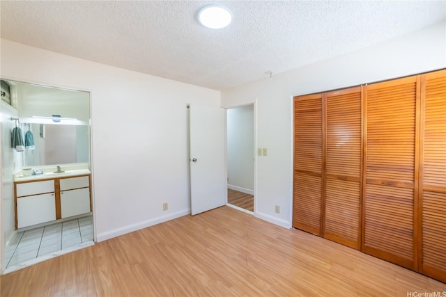 83 Iho Iho Pl, Wahiawa, HI 96786 - unfurnished bedroom with wood finished floors, a textured ceiling, a closet, and ensuite bathroom