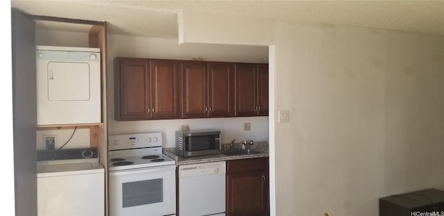 1630 Liholiho St Unit 2205, Honolulu, HI 96822 - kitchen with white appliances, estacked washer and dryer, a sink, light countertops, and a textured ceiling