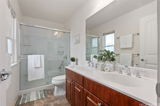 bathroom featuring vanity, toilet, and a shower with shower door