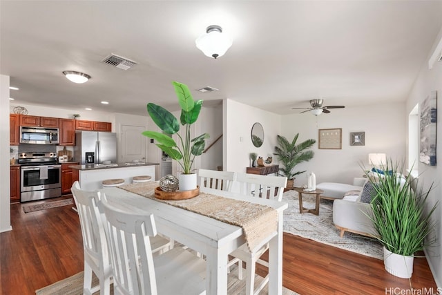 dining area with ceiling fan and dark hardwood / wood-style floors