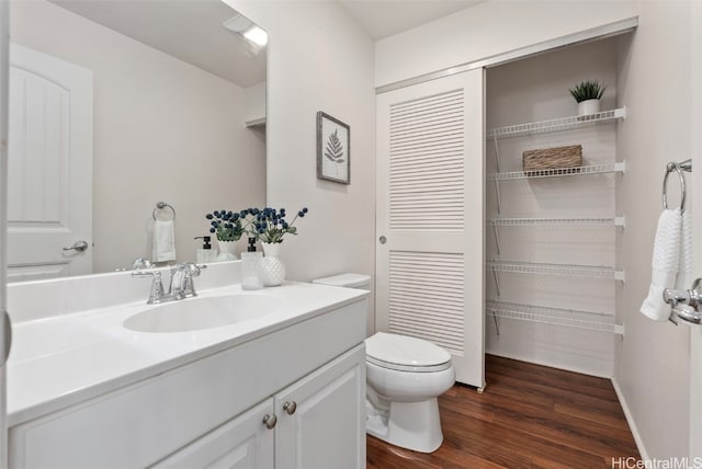 bathroom featuring hardwood / wood-style flooring, vanity, and toilet