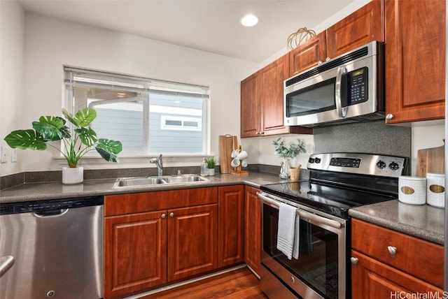 kitchen with dark hardwood / wood-style floors, sink, decorative backsplash, and stainless steel appliances