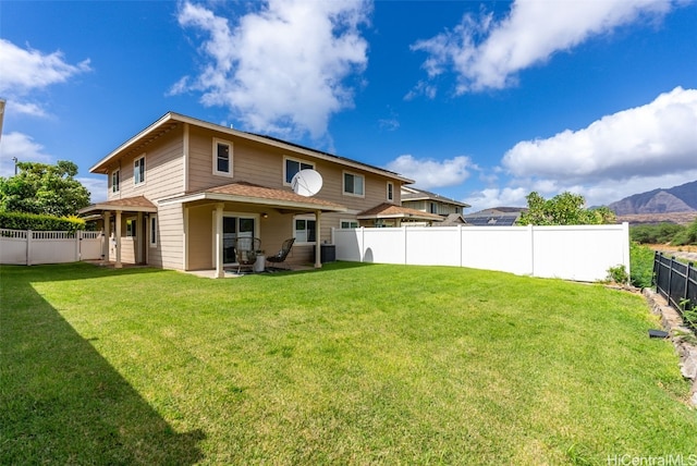 rear view of property with a lawn, a mountain view, cooling unit, and a patio