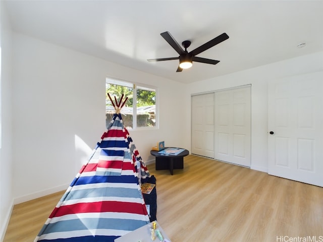 bedroom with a closet, light wood-type flooring, and ceiling fan