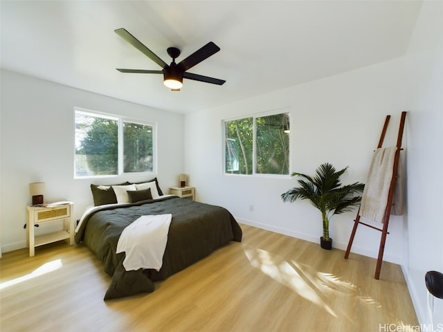 bedroom with light wood-type flooring, multiple windows, and ceiling fan