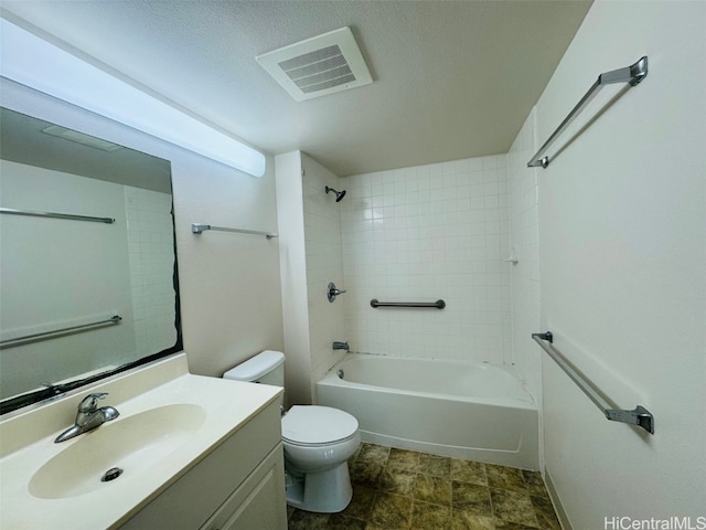 full bathroom with tiled shower / bath, vanity, a textured ceiling, and toilet