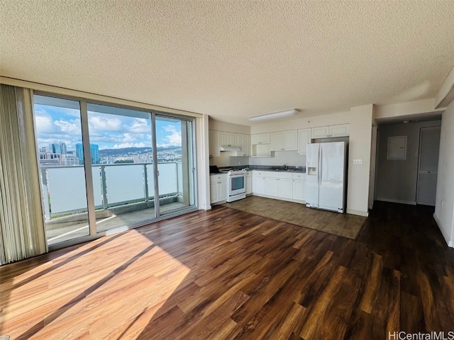 kitchen featuring white cabinets, white appliances, dark wood-type flooring, and a textured ceiling