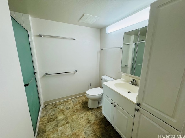 bathroom with vanity, toilet, and a shower with shower door