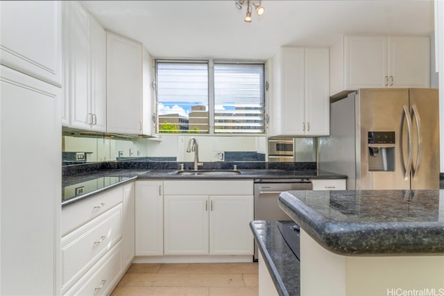 kitchen with dark stone countertops, sink, white cabinets, and stainless steel appliances