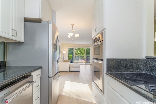 kitchen with stainless steel appliances, white cabinetry, and light hardwood / wood-style floors