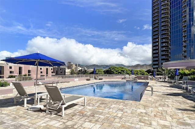 view of pool featuring a mountain view and a patio