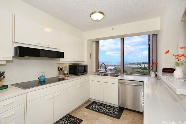 kitchen with black appliances, white cabinetry, sink, and a textured ceiling