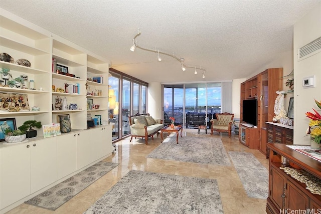 living room with expansive windows and a textured ceiling