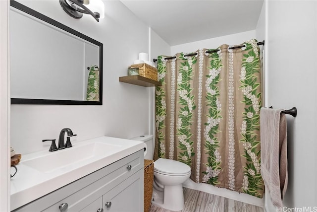 bathroom with hardwood / wood-style flooring, vanity, and toilet