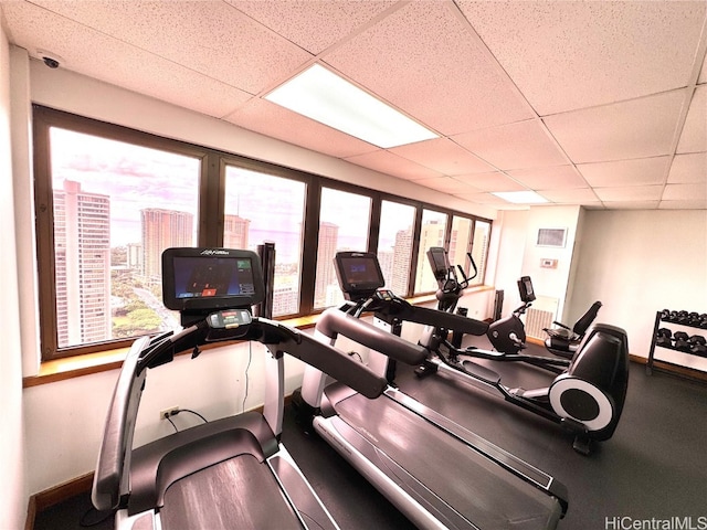 workout area with a paneled ceiling and a healthy amount of sunlight