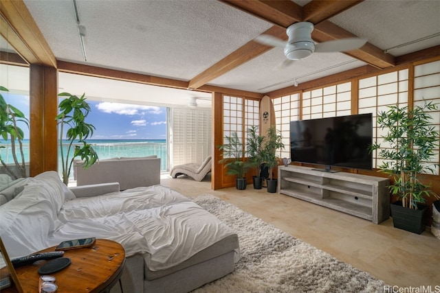 bedroom with beamed ceiling, ceiling fan, a textured ceiling, and multiple windows