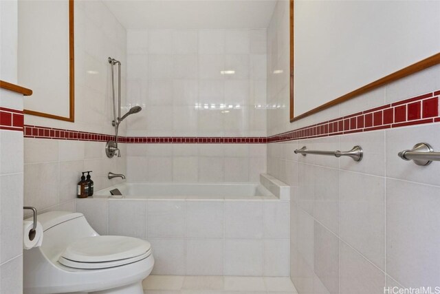 bathroom featuring tile walls and toilet