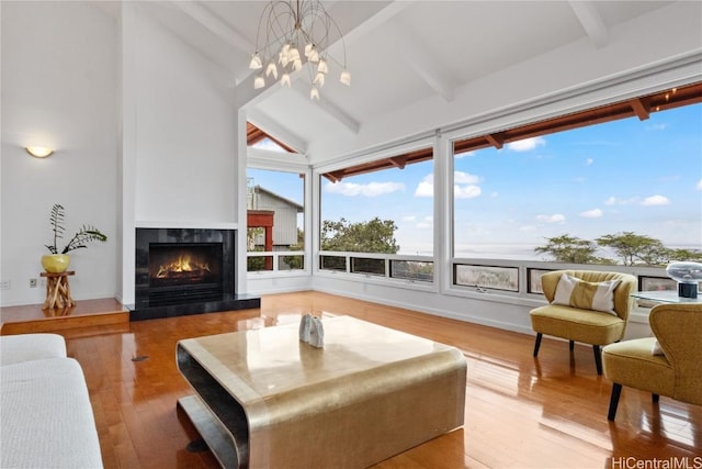 living room with high vaulted ceiling, a fireplace, light wood-type flooring, a notable chandelier, and beam ceiling