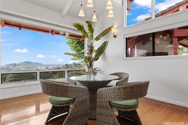 sunroom / solarium featuring beamed ceiling and a mountain view