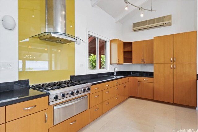 kitchen with sink, beam ceiling, island exhaust hood, an AC wall unit, and stainless steel gas stovetop