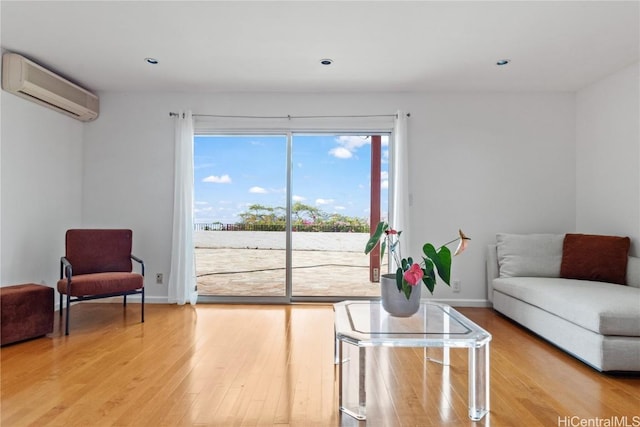 living room featuring wood-type flooring and a wall unit AC