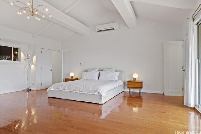 bedroom featuring lofted ceiling with beams, a wall mounted AC, a notable chandelier, and light hardwood / wood-style floors