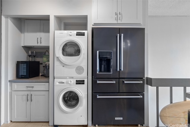 laundry room featuring a textured ceiling and stacked washer / dryer