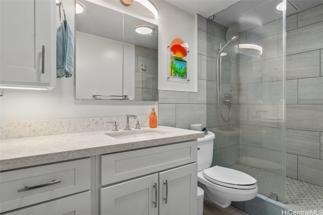 bathroom featuring vanity, an enclosed shower, and toilet