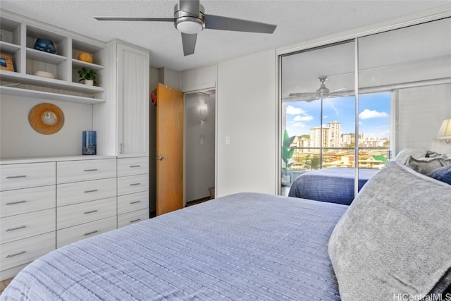 bedroom featuring access to outside, ceiling fan, and a textured ceiling