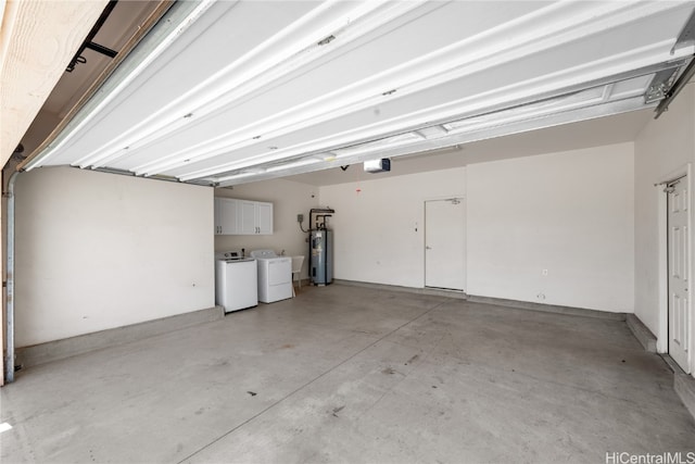 garage featuring electric water heater, a garage door opener, and washing machine and clothes dryer