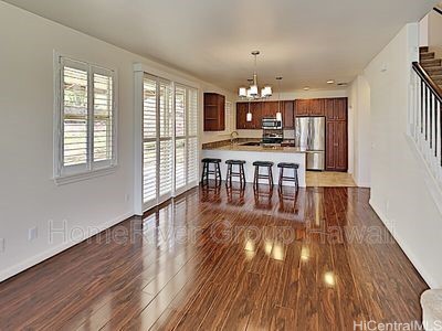 kitchen with stainless steel appliances, dark wood-type flooring, kitchen peninsula, decorative light fixtures, and a breakfast bar