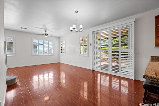 interior space with ceiling fan with notable chandelier, dark hardwood / wood-style floors, and plenty of natural light