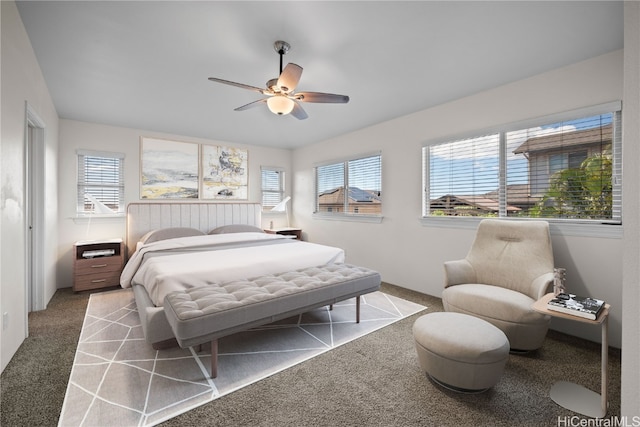 carpeted bedroom featuring multiple windows and ceiling fan