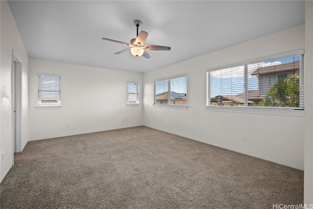 carpeted spare room featuring ceiling fan and a healthy amount of sunlight