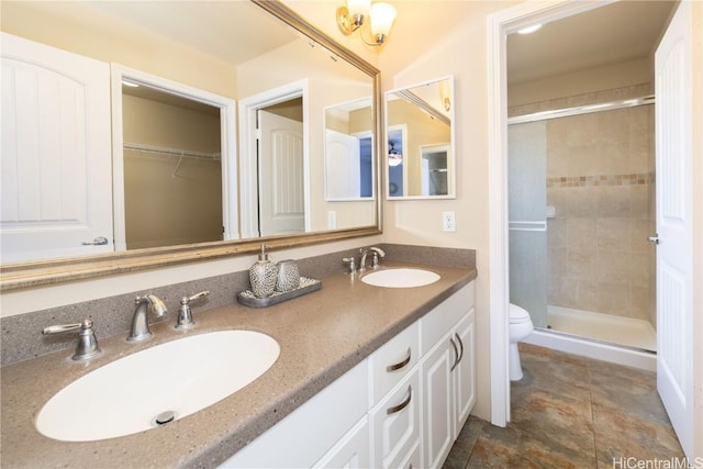 bathroom featuring vanity, toilet, and a shower with door