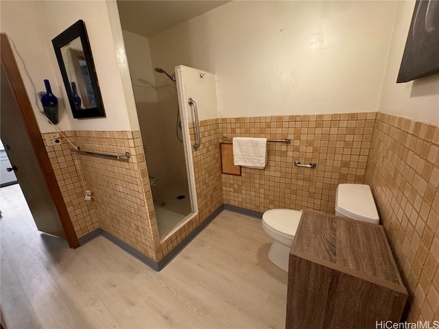 bathroom featuring walk in shower, tile walls, hardwood / wood-style floors, and toilet