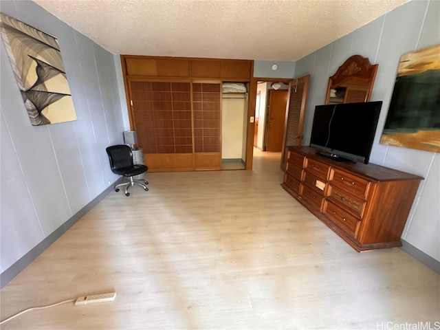 living room with a textured ceiling and light hardwood / wood-style flooring