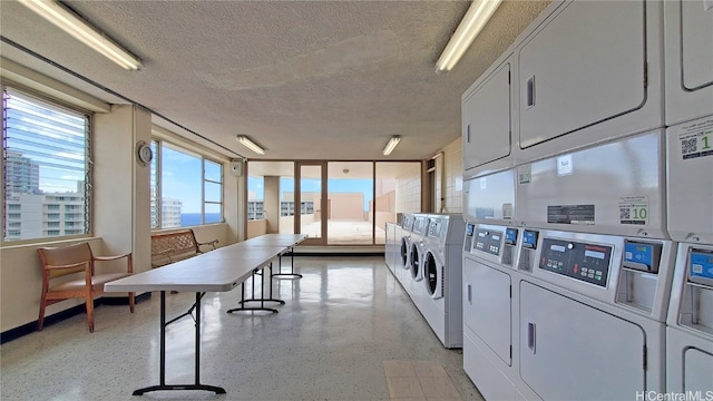 washroom with stacked washing maching and dryer and a textured ceiling