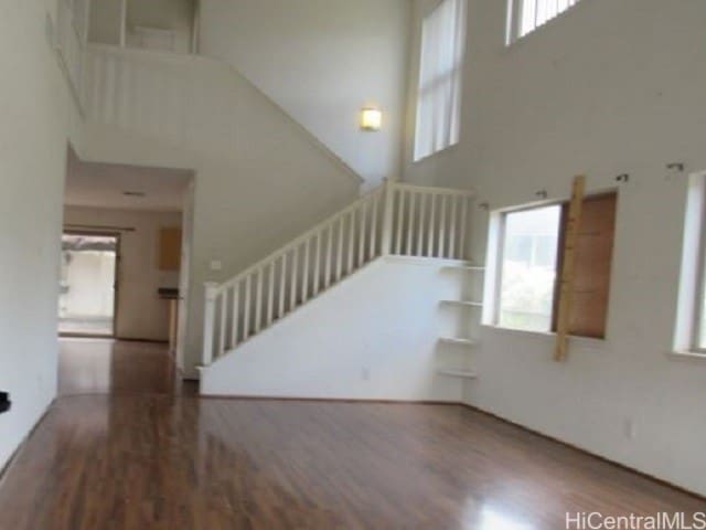 interior space with a towering ceiling and hardwood / wood-style flooring