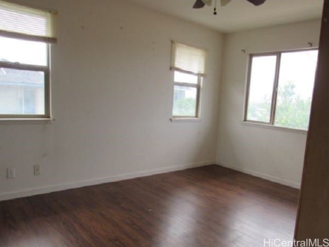 spare room featuring ceiling fan and dark wood-type flooring