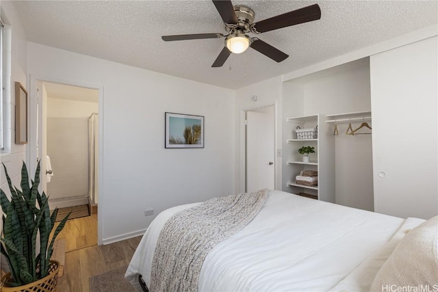 bedroom with ceiling fan, wood-type flooring, a textured ceiling, and a closet