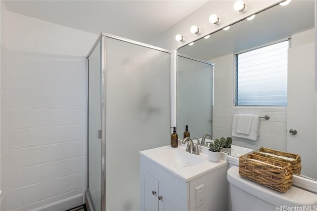 bathroom featuring vanity, an enclosed shower, and toilet