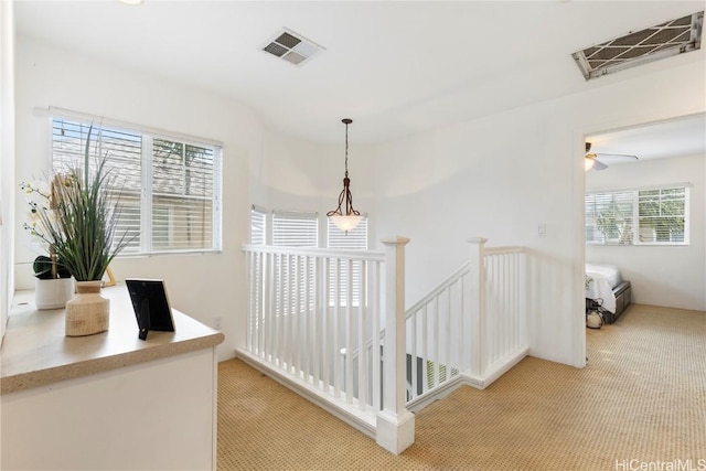 hallway featuring light colored carpet